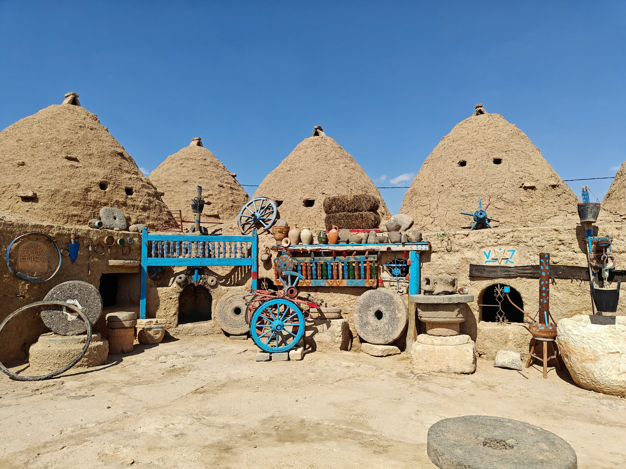 a group of stone buildings with a blue cart in front of them