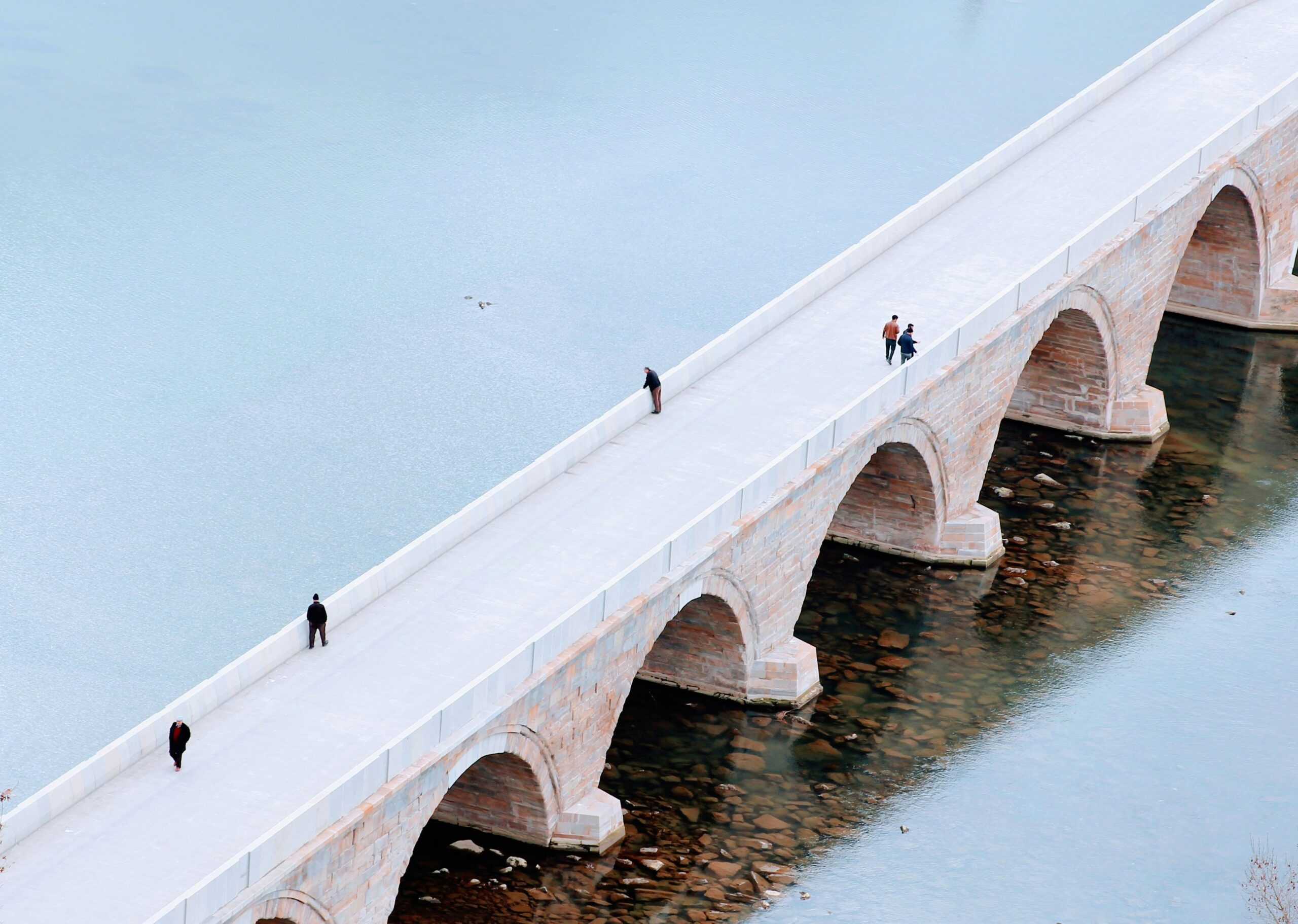people walking on white concrete bridge during daytime